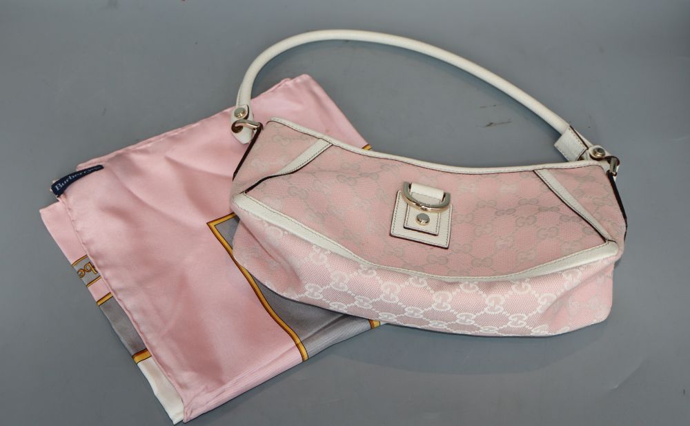 A Gucci pink lace-style handbag and a Burberry scarf